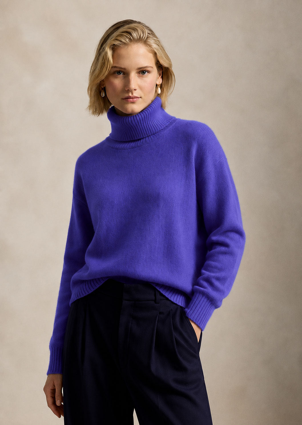 Model in an oversized violet roll-neck sweater and navy trousers